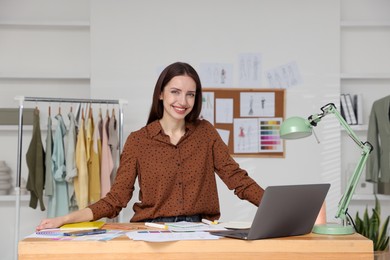 Photo of Fashion designer working at wooden table in workshop