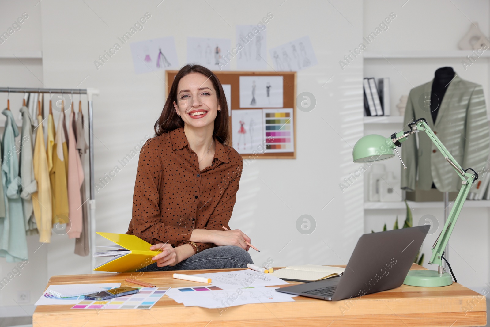 Photo of Fashion designer working at wooden table in workshop