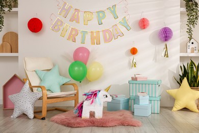 Photo of Bright pinata in shape of unicorn and party accessories in festive decorated room