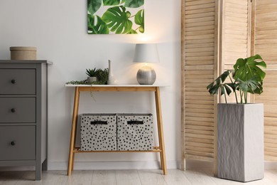 Photo of Stylish room interior with console table near white wall