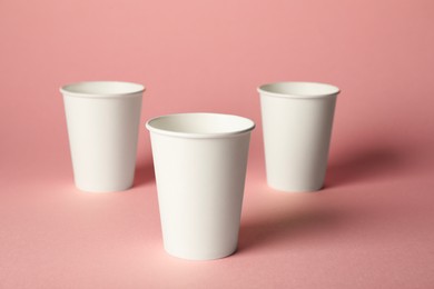 Photo of Paper cups on pink background. Mockup for design