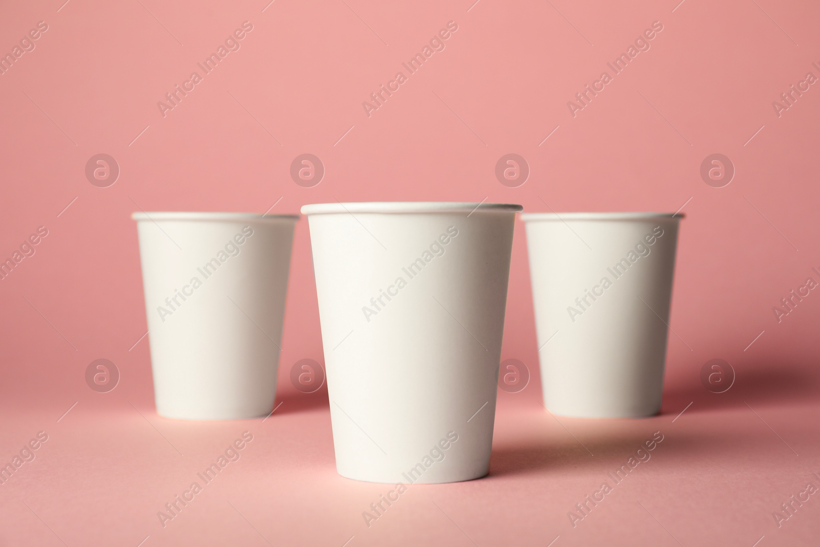 Paper cups on pink background. Mockup for design Photo of Paper cups on pink background. Mockup for design