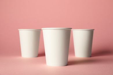 Photo of Paper cups on pink background. Mockup for design