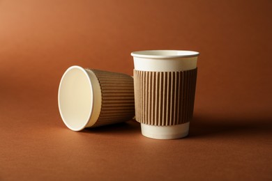 Photo of Paper cups on brown background. Mockup for design