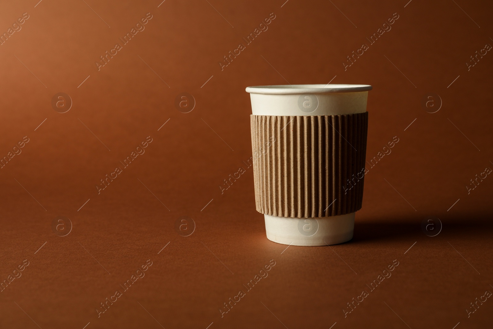 One paper cup on brown background. Mockup for design Photo of One paper cup on brown background. Mockup for design
