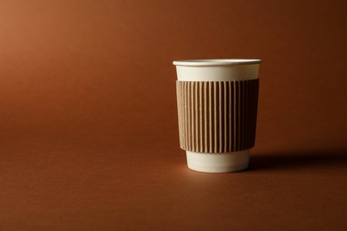 Photo of One paper cup on brown background. Mockup for design