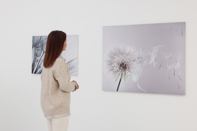 Photo of Woman studying beautiful artwork in modern gallery