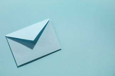 Photo of Paper envelope on light blue background, top view. Mockup for design