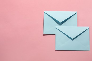 Photo of Paper envelopes on pink background, top view. Mockup for design