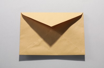 Photo of Kraft paper envelope on grey background, top view. Mockup for design