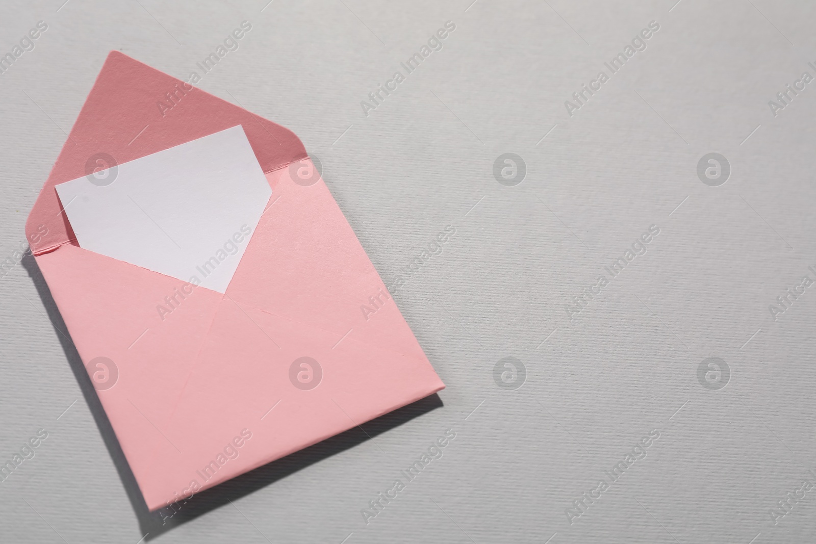 Photo of Paper envelope with letter on grey background, above view. Mockup for design