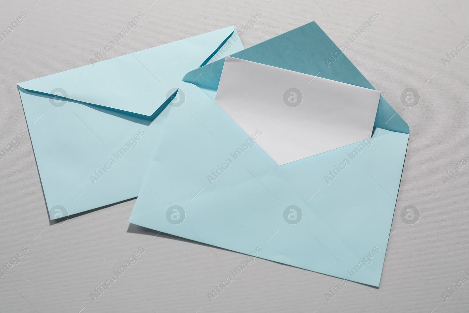 Photo of Paper envelopes with letter on grey background, top view. Mockup for design