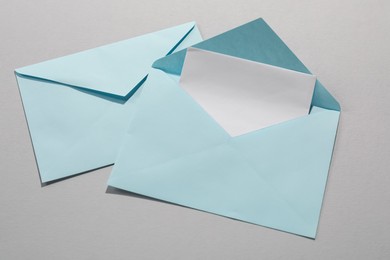 Photo of Paper envelopes with letter on grey background, top view. Mockup for design