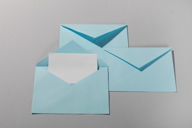 Photo of Paper envelopes with letter on grey background, flat lay. Mockup for design