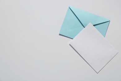 Photo of Paper envelope with letter on white background, top view. Mockup for design