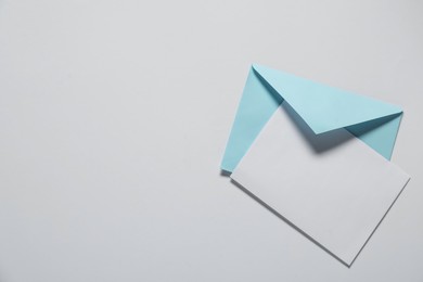 Photo of Paper envelope with letter on white background, top view. Mockup for design