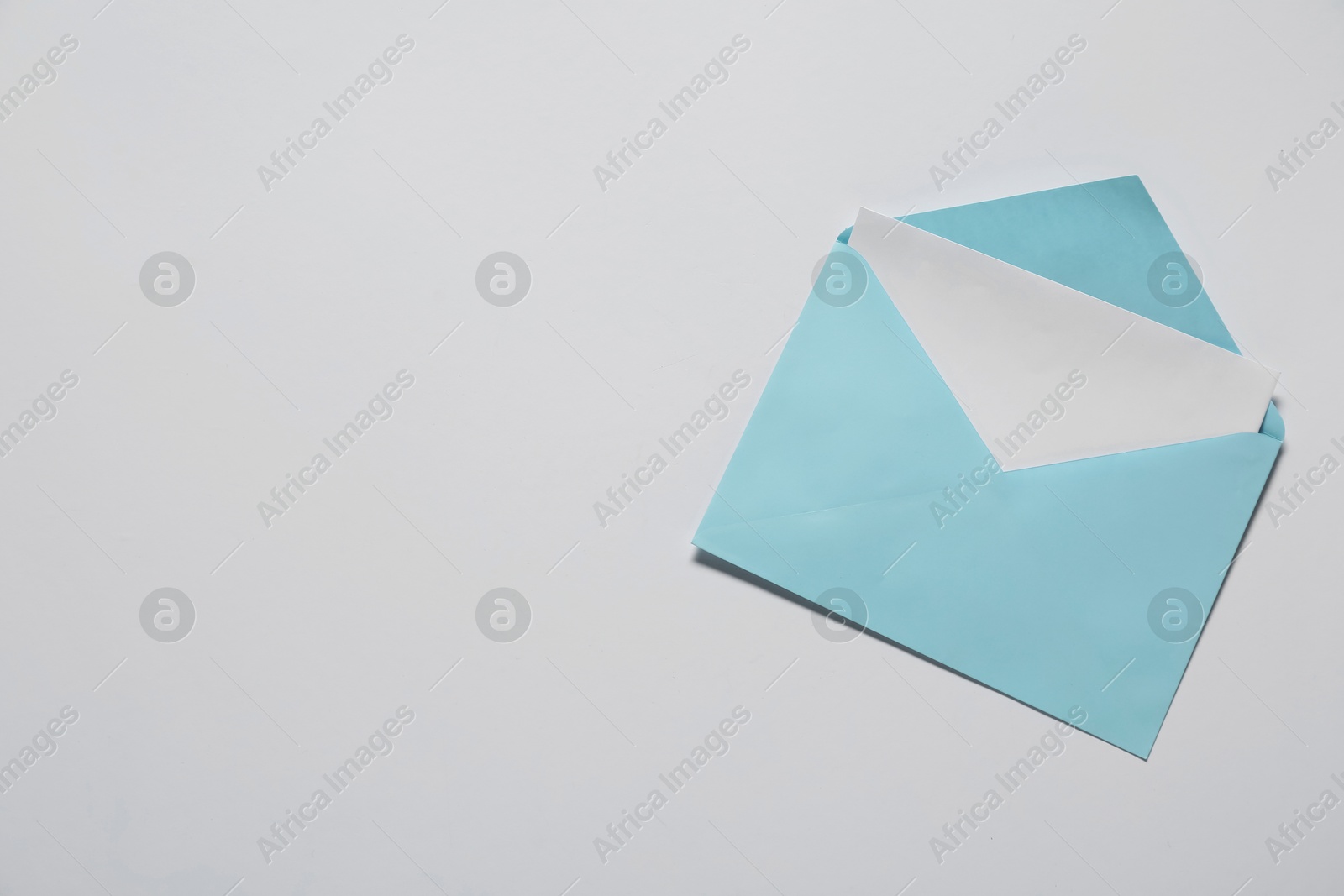 Photo of Paper envelope with letter on white background, top view. Mockup for design