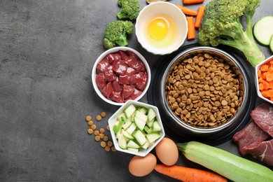 Photo of Dry pet food and natural products on grey table, top view