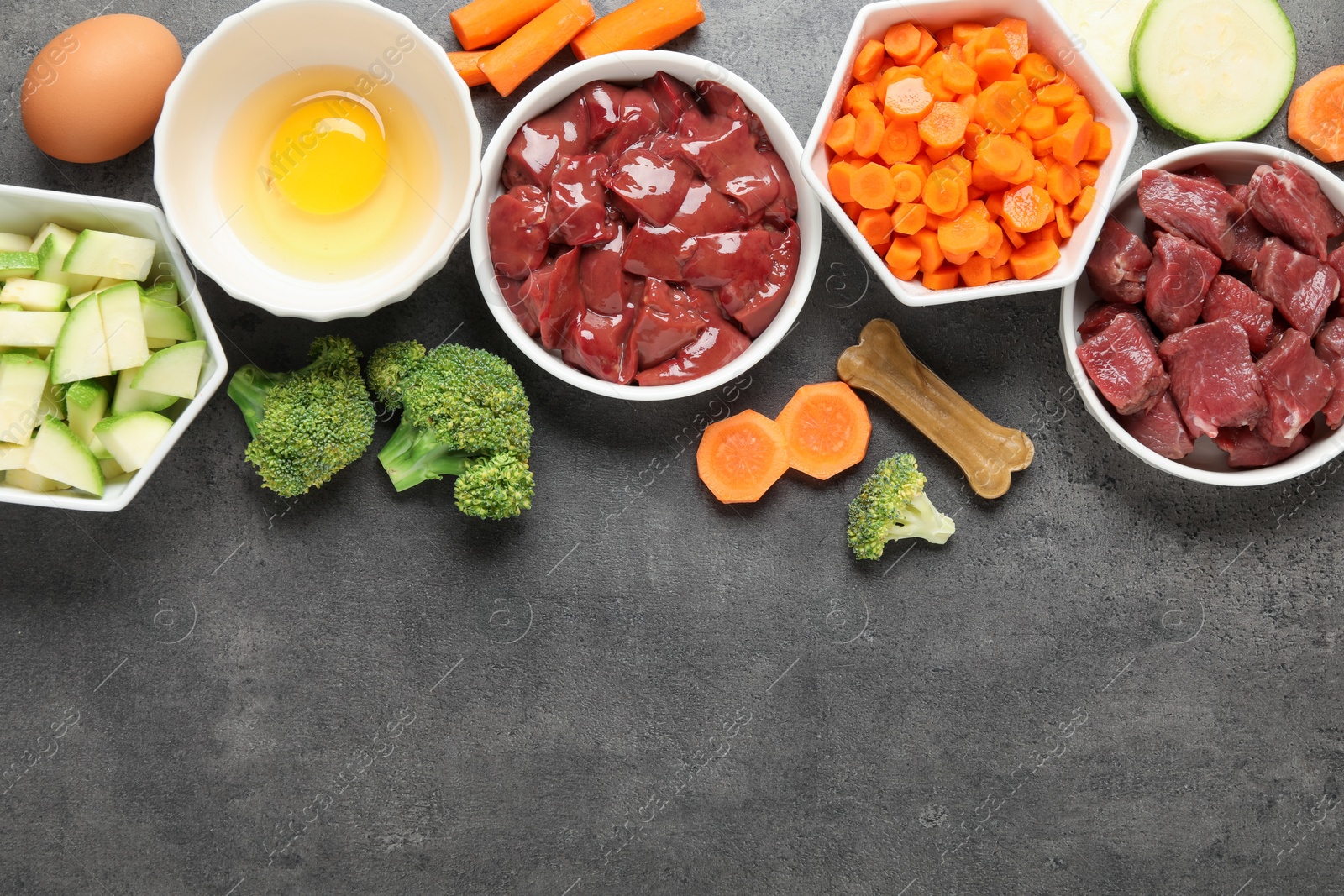 Photo of Pet food. Natural products on grey table, top view. Space for text