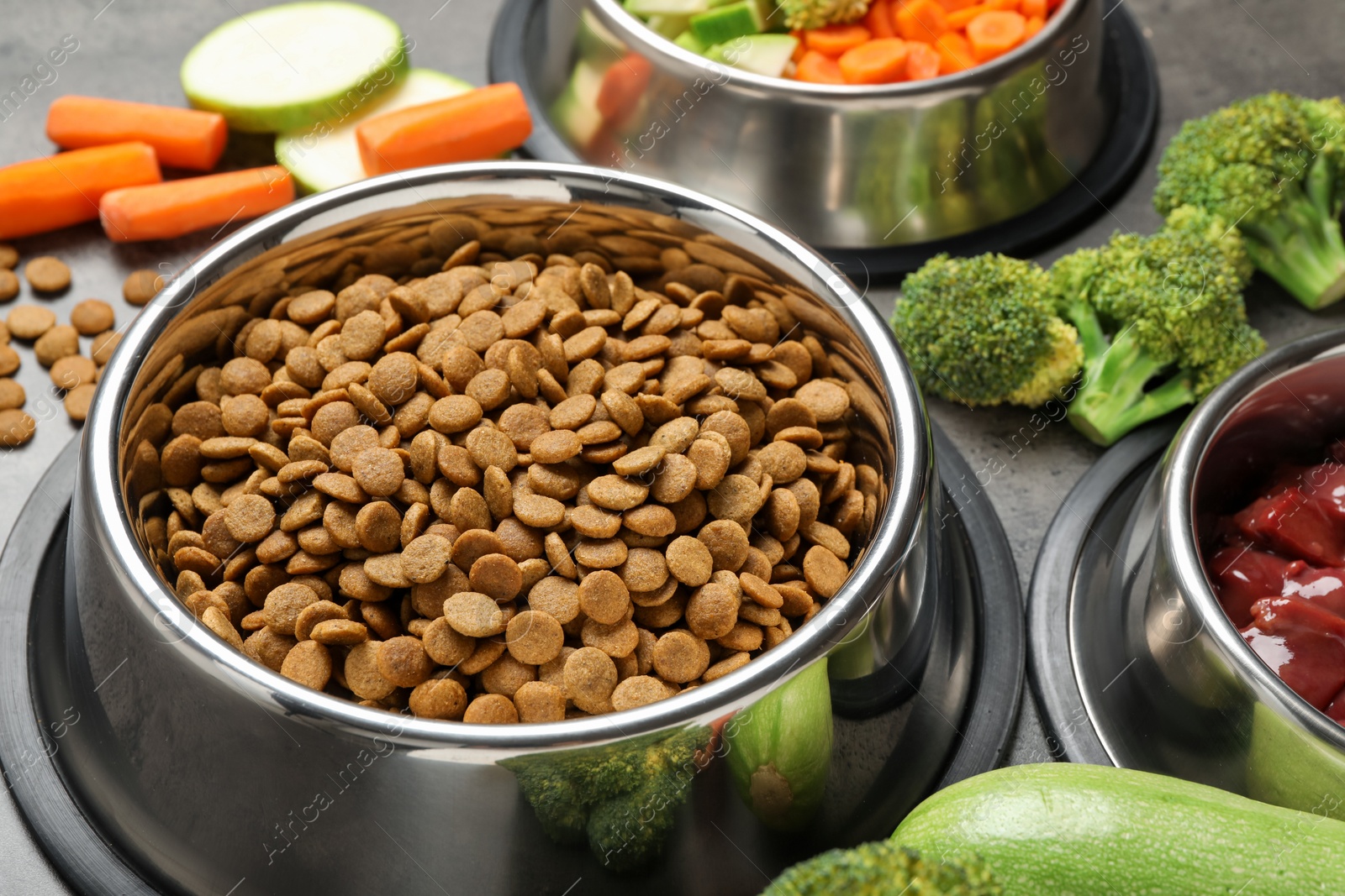 Photo of Dry pet food and natural products on grey table, closeup