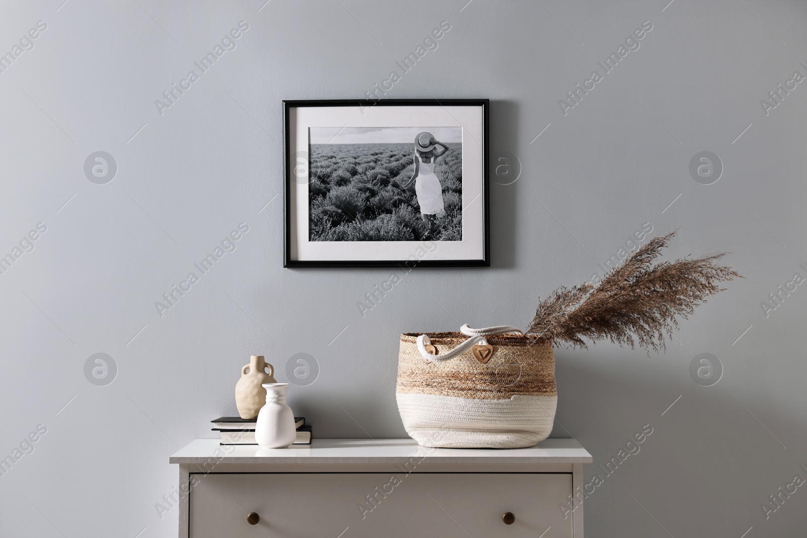 Photo of Console table with decor and books light grey wall. Interior design