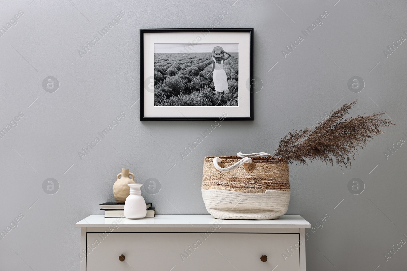 Photo of Console table with decor and books light grey wall. Interior design