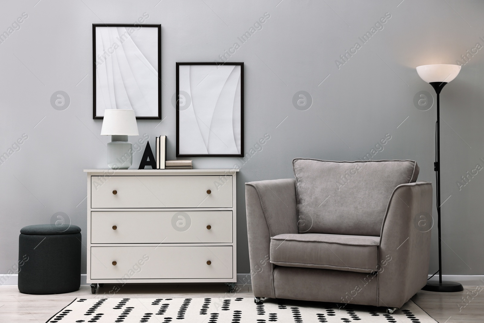 Photo of Dresser and other furniture near light grey wall in room. Interior design