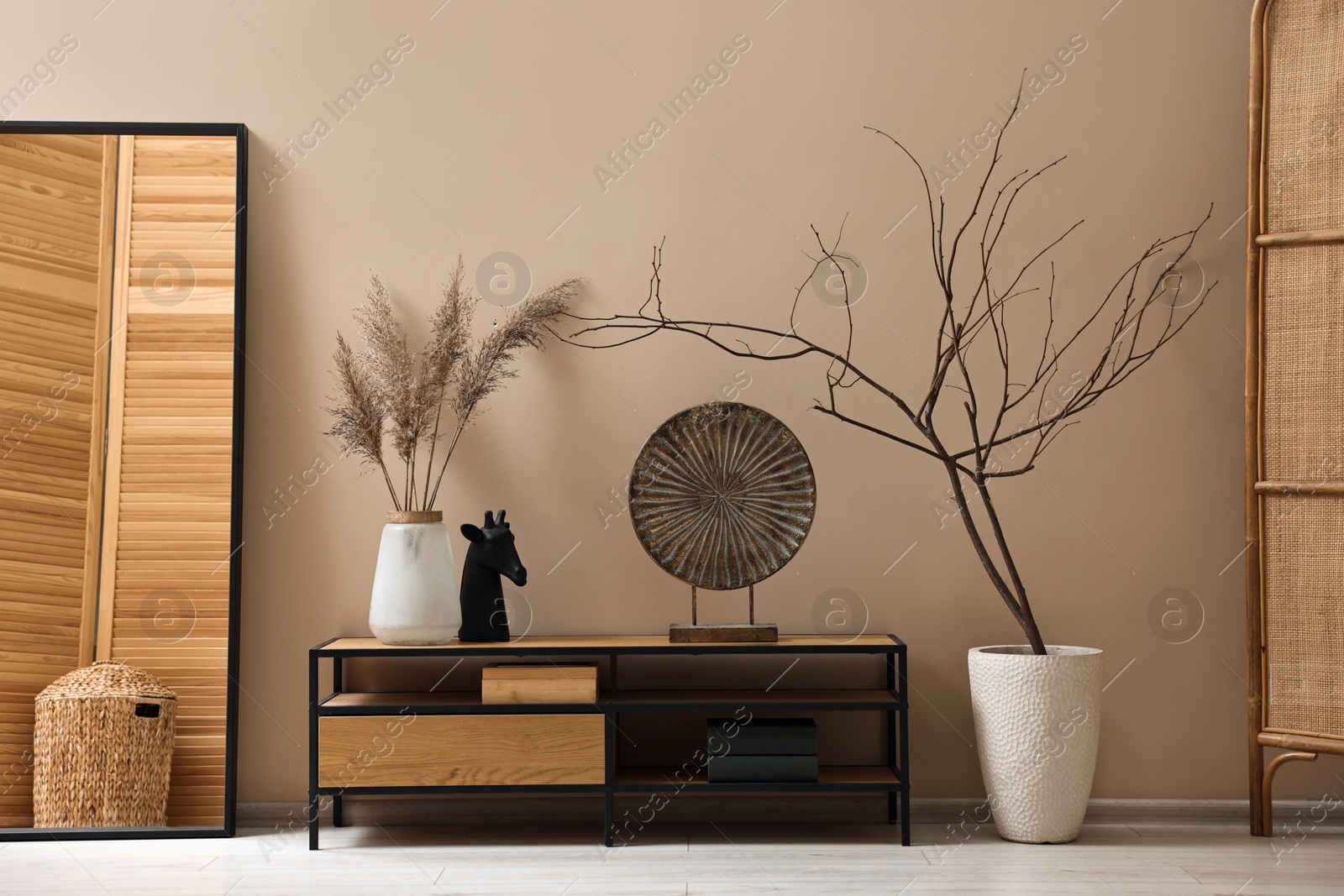 Photo of Console table and decor near dark beige wall in room. Interior design