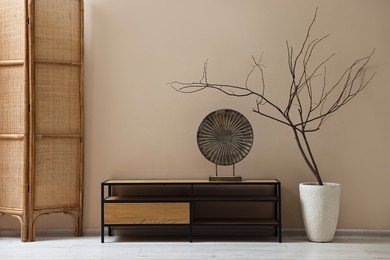 Photo of Console table and decor near dark beige wall in room. Interior design