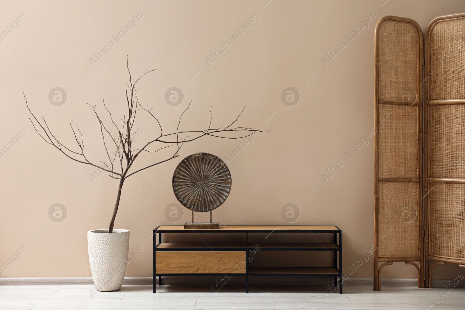 Photo of Console table and decor near dark beige wall in room. Interior design