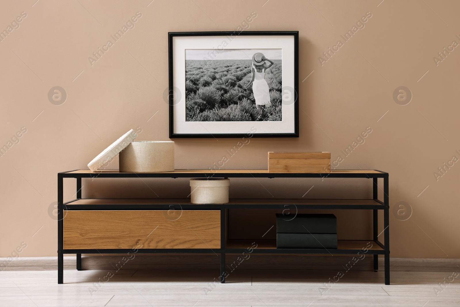 Photo of Console table and decor near dark beige wall in room. Interior design