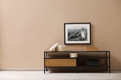 Photo of Console table and decor near dark beige wall in room, space for text. Interior design