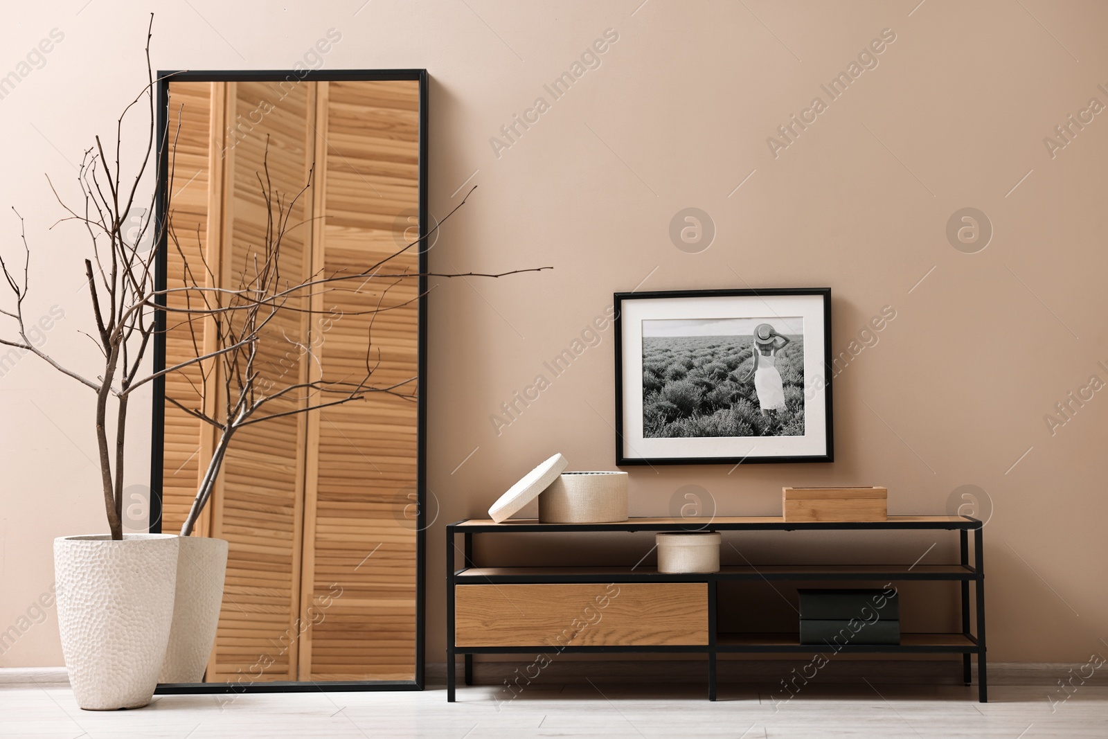 Photo of Console table and decor near dark beige wall in room. Interior design