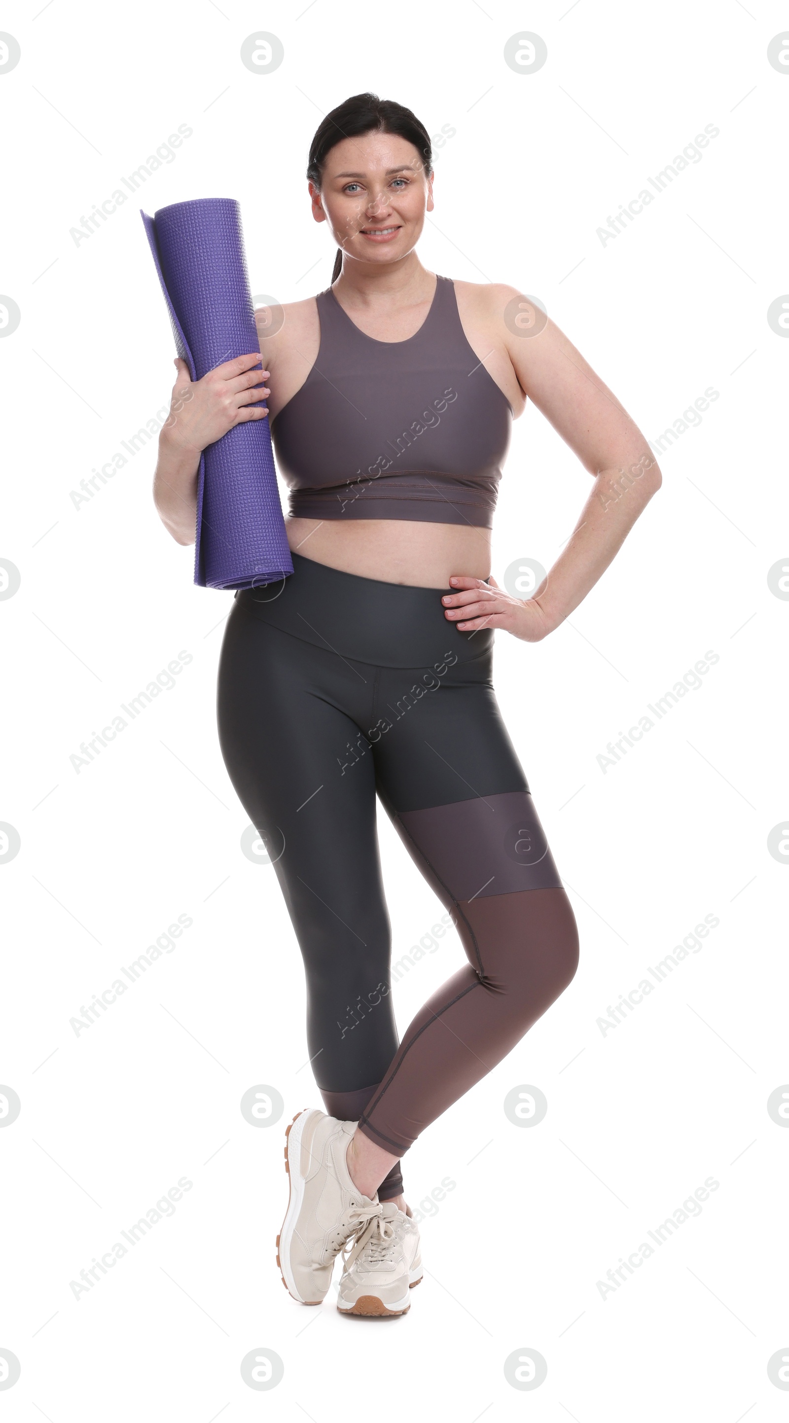 Photo of Plus size woman in gym clothes with fitness mat on white background