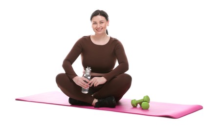 Photo of Plus size woman in gym clothes with water bottle, dumbbells and mat on white background