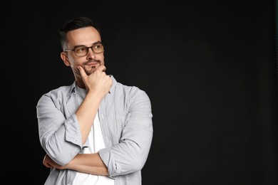 Photo of Portrait of handsome middle aged man on black background, space for text