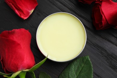 Photo of Natural solid perfume and roses on black wooden table, top view