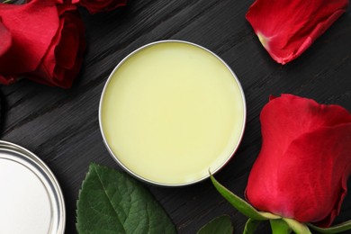 Photo of Natural solid perfume and roses on black wooden table, top view