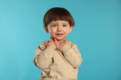 Photo of Portrait of cute little boy on light blue background