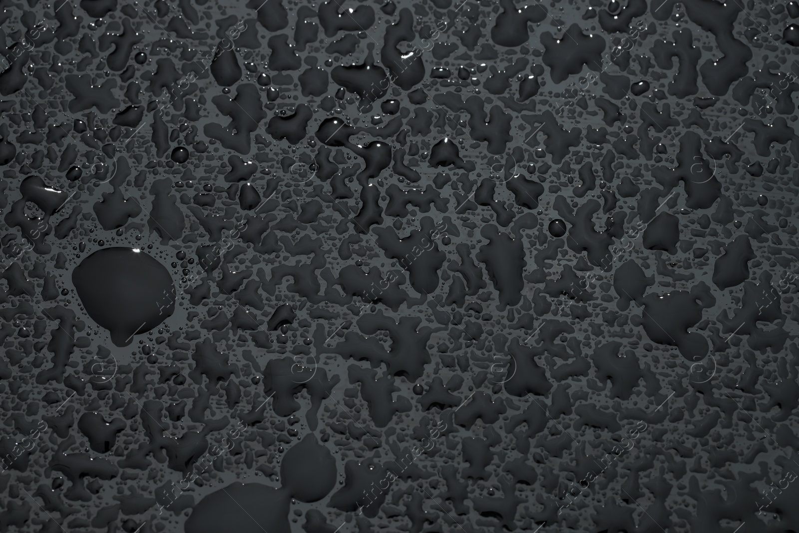 Photo of Water drops on grey glass surface, top view