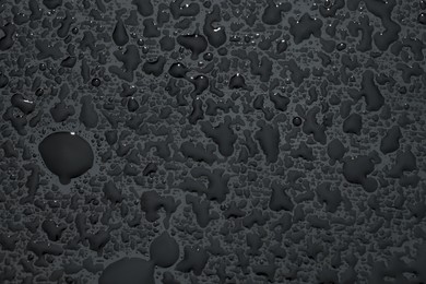 Photo of Water drops on grey glass surface, top view