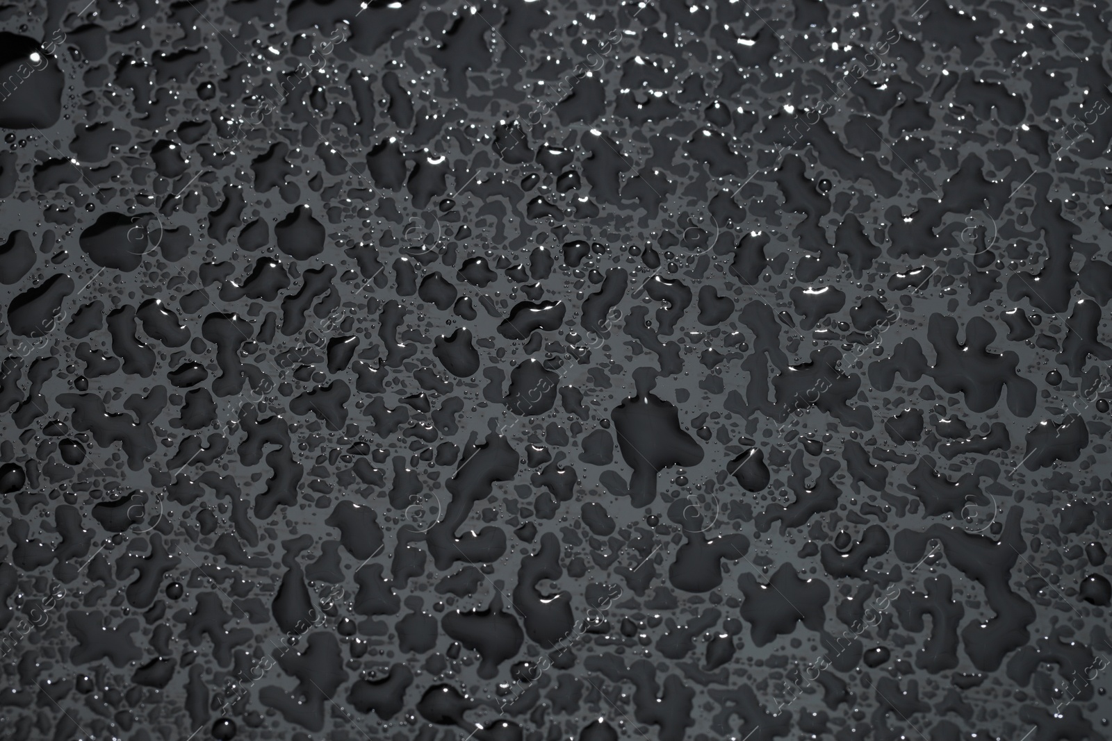 Photo of Water drops on grey glass surface, top view