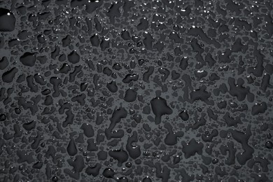 Photo of Water drops on grey glass surface, top view