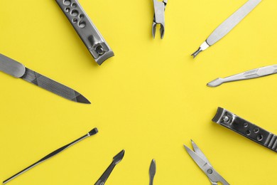 Photo of Frame of pedicure tools on yellow background, flat lay. Space for text