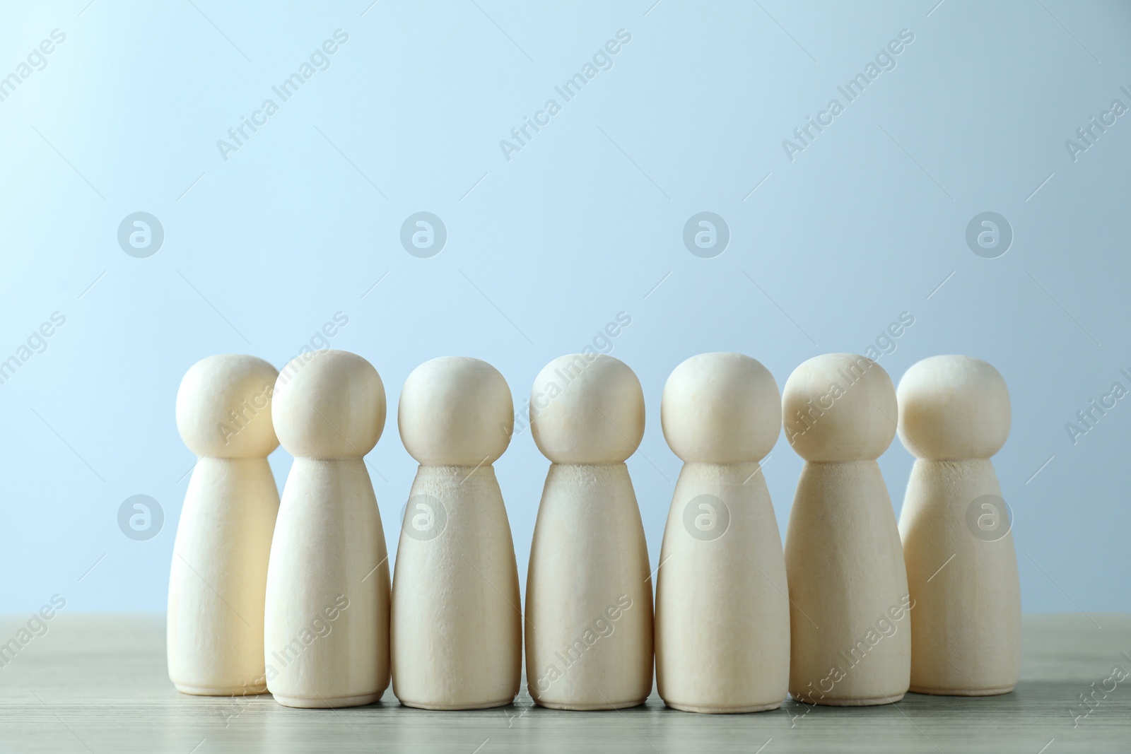 Photo of Human resources concept. Many wooden figures on table against light background, closeup. Space for text