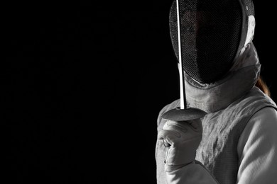 Photo of Fencer with epee on black background, space for text