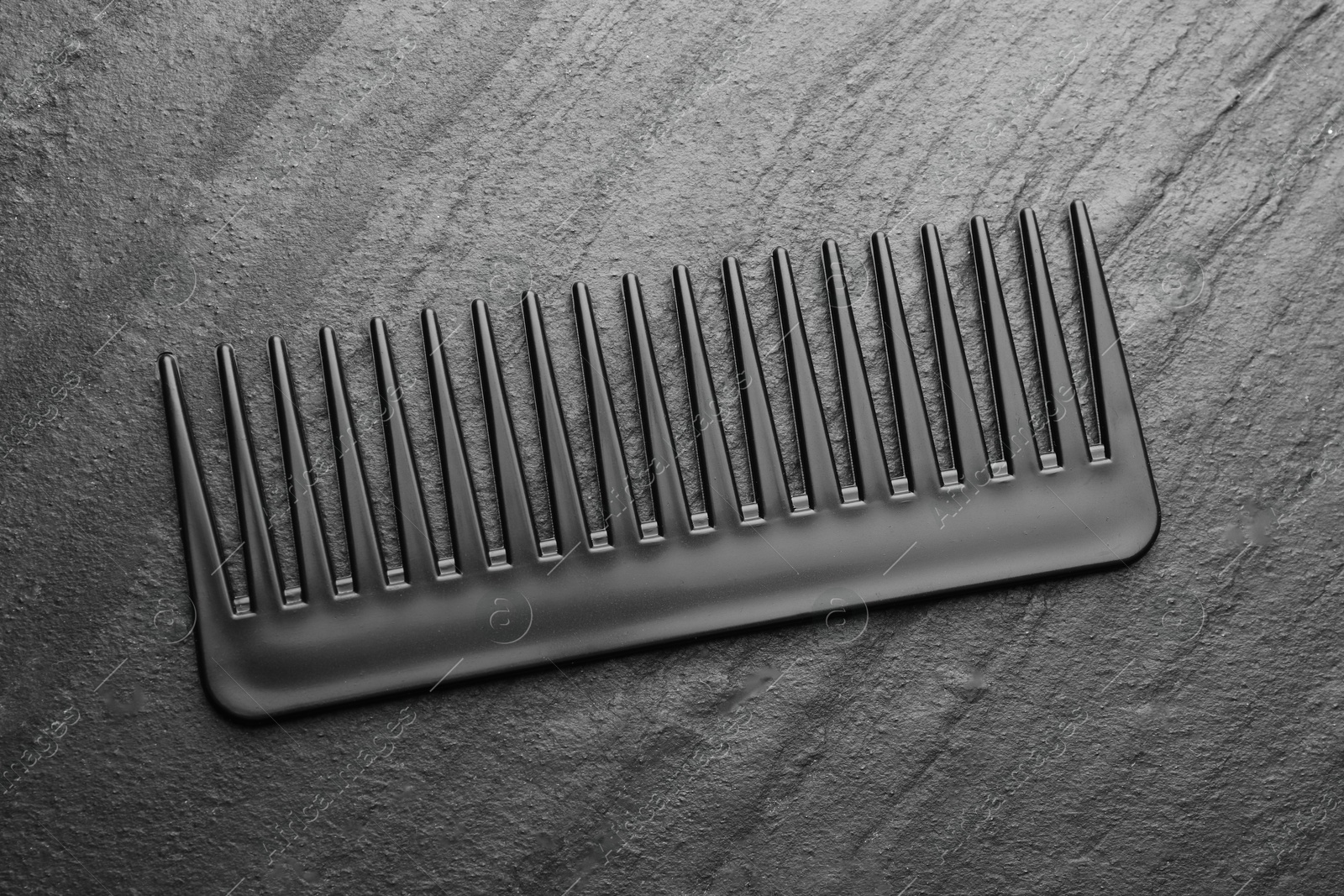 Photo of One plastic hair comb on grey background, top view