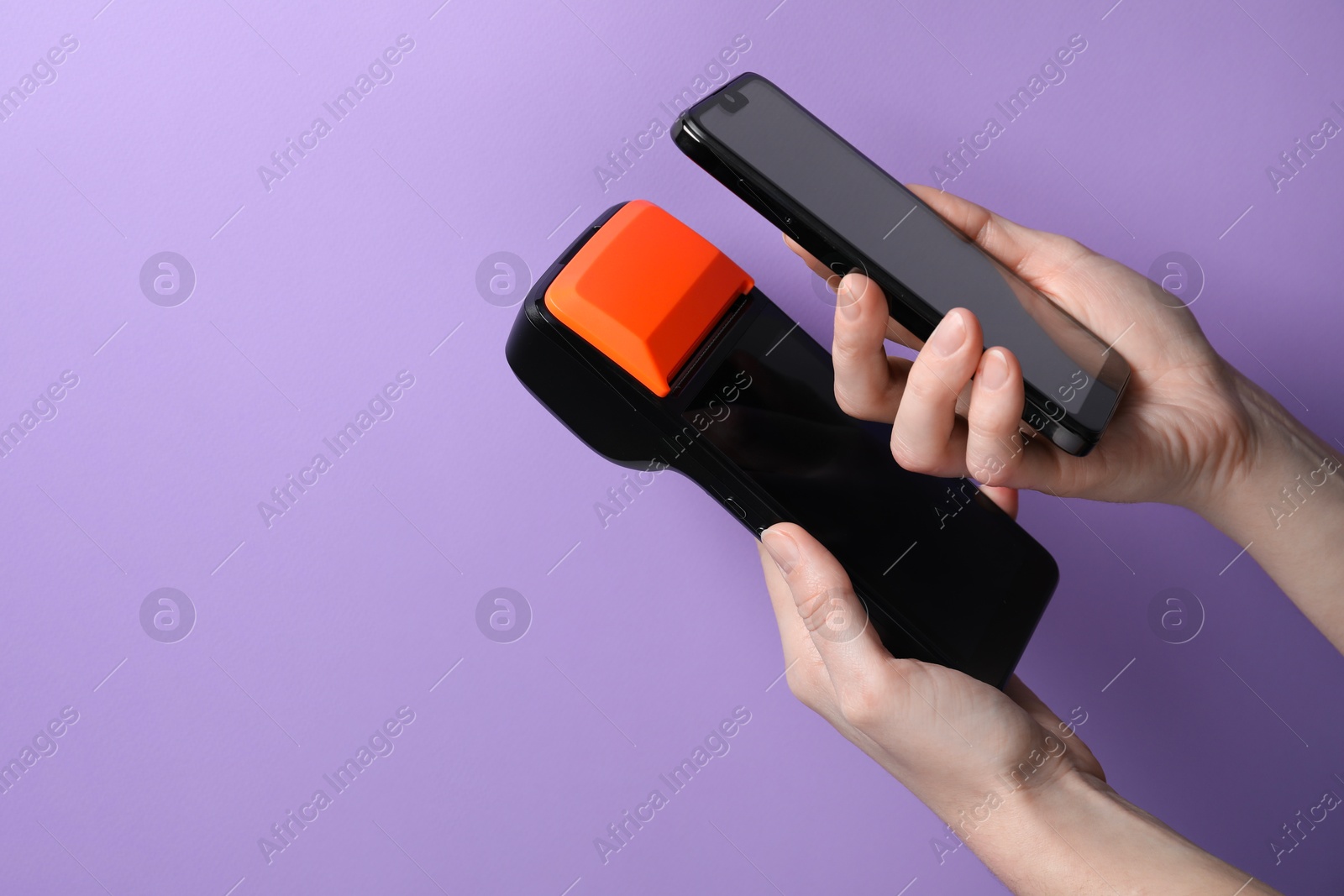 Photo of Woman with smartphone using payment terminal on violet background, closeup. Space for text