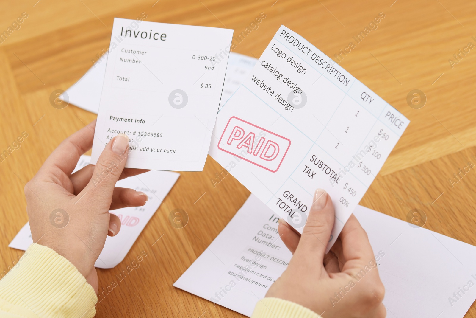 Photo of Paying bills. Woman with different invoices at wooden table indoors, closeup