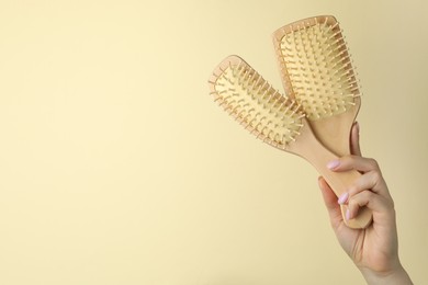 Photo of Woman with wooden brushes on beige background, closeup. Space for text